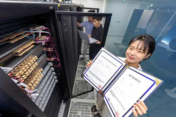 KT 직원이 ‘KT 매니지드 프라이빗 클라우드’로 획득한 국가정보원의 보안기능확인서를 들고 있다./사진=KT