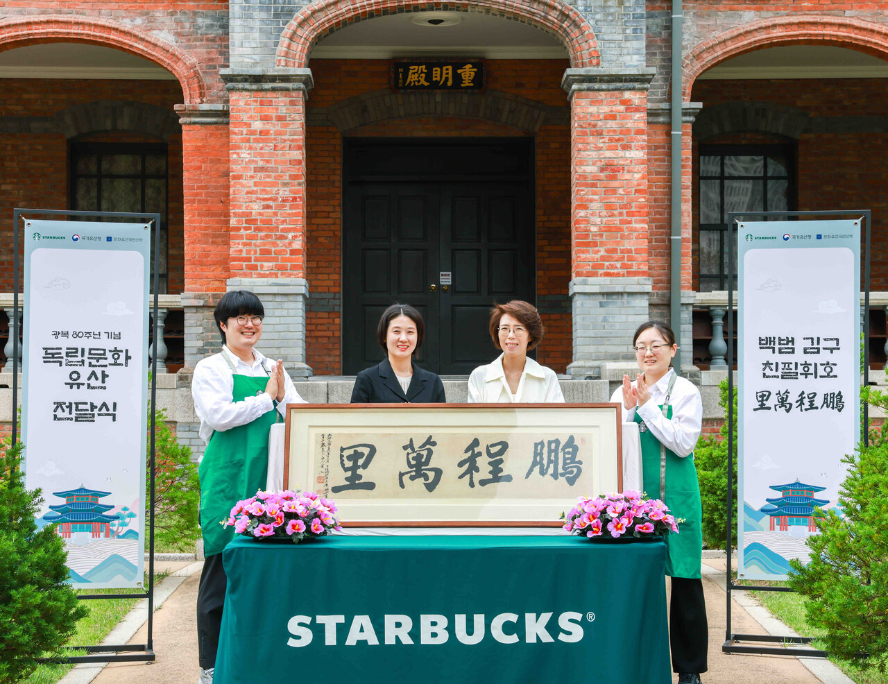 2025년 8월 11일 서울 중구 덕수궁 중명전에서 열린 광복 80주년 기념 독립문화유산 전달식에서 (오른쪽 두번째)김영경 문화유산국민신탁 부장을 비롯해 행사 관계자들이 백범 김구 친필휘호 ‘붕정만리(鵬程萬里)’를 앞에 두고 기념사진을 촬영하고 있다. 2025.8.13./사진=스타벅스 코리아