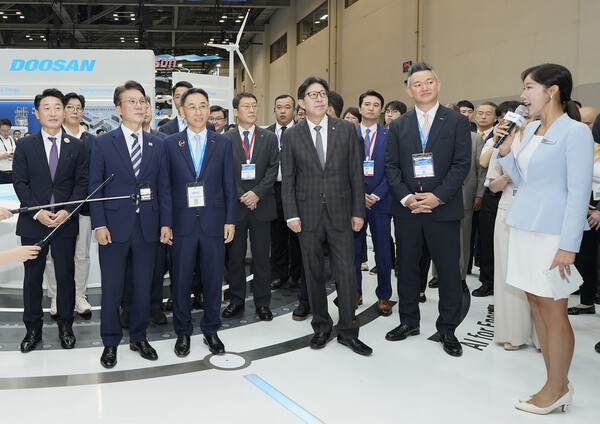 2025년 8월 27일 ‘기후산업국제박람회’ 두산 부스에 방문한 (앞줄 왼쪽부터) 이호현 산업통상자원부 2차관, 김민석 국무총리, 정연인 두산에너빌리티 부회장, 박형준 부산광역시장이 두산그룹의 에너지 솔루션 기술을 살펴보고 있다./사진=두산