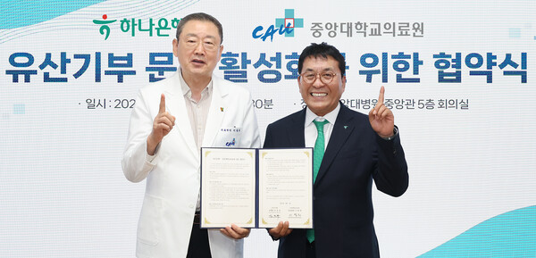하나은행은 2025년 9월 4일 서울 동작구 중앙대학교병원 중앙대학교병원 중앙관 5층 회의실에서 중앙대학교의료원과 유산 기부 활성화를 위한 업무협약을 체결했다. 협약식에 참석한 김진우 하나은행 중앙영업그룹 부행장(사진 오른쪽)이 이철희 중앙대학교의료원장과 협약서를 들고 기념촬영을 하고 있다./사진=하나은행