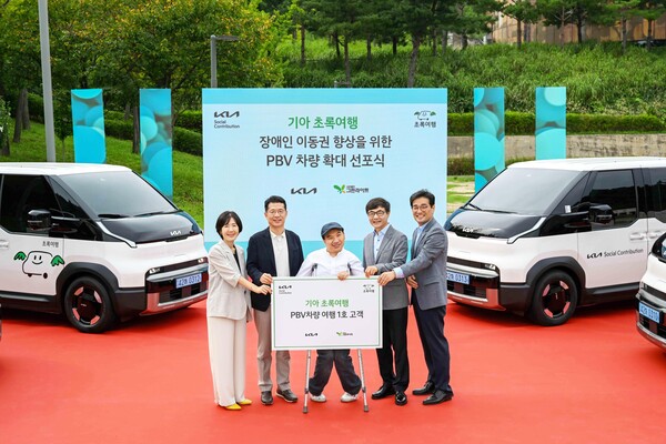 기아 지속가능경영실장 이덕현 상무(왼쪽 두번째), 사단법인 그린라이트 이재강 회장(왼쪽 네번째) 등 주요 관계자들이 PV5 여행 1호 고객과 기념 촬영을 하고 있다./사진=기아