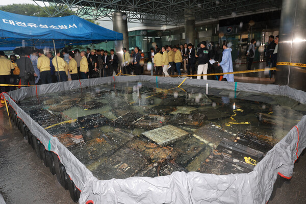 28일 대전 유성구 국가정보자원관리원 화재 현장에서 국립과학수사연구원 관계자가 소화수조에 담긴 배터리를 살피고 있다.지난 26일 정부 전산시스템이 있는 국정자원에서 무정전·전원 장치(UPS)용 리튬이온배터리 화재가 발생해 정부 전산 서비스가 대규모로 마비된 바 있다. 2025.9.28./연합