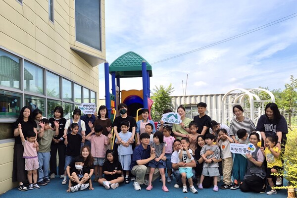 구미 하늘어린이집 원아와 교사가 '2025 리빙인하모니'를 통해 개선된 외부놀이공간에서 기념사진을 촬영하고 있다. /2025.9.29 우미희망재단