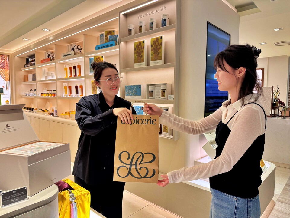 고객이 서울시 중구 소공동에 위치한 롯데백화점 본점 지하 1층에서 바로 픽업 상품을 건네받고 있다. 2025.10.2./사진=롯데쇼핑