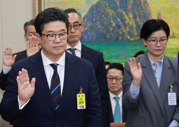 김병주 MBK파트너스 회장(왼쪽)이 2025년 10월 14일 서울 여의도 국회에서 열린 공정거래위원회, 개인정보보호위원회 등에 대한 정무위원회 국정감사에서 선서하고 있다./연합