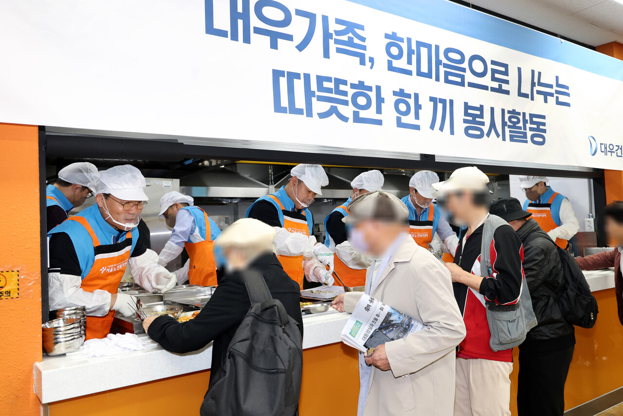 2025년 10월 21일 서울노인복지센터에서 진행된 취약계층 어르신 대상 무료 급식 봉사활동 '대우건설 Day'에 참여한 김보현 대우건설 대표(왼쪽)와 심상철 노동조합 위원장(오른쪽)이 임직원들과 함께 음식을 배식하고 있다. 2025.10.22./사진=대우건설