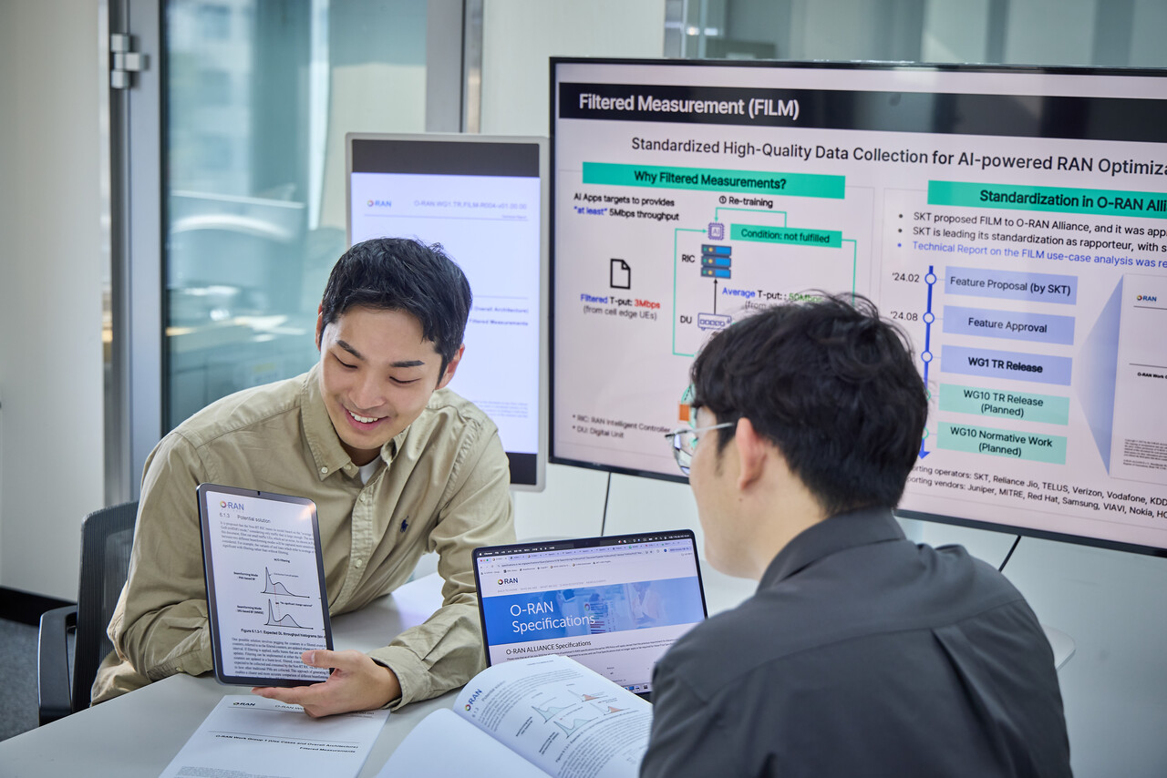 SK텔레콤 관계자들이 글로벌 오픈랜 표준화 기구 O-RAN 얼라이언스(O-RAN Alliance)에서 자사가 새롭게 발간한 무선망 데이터 수집 고도화 기술 ‘Filtered Measurements(FILM)’에 대한 기술 문서를 살펴보고 있다. 2025.10.29./사진=SK텔레콤