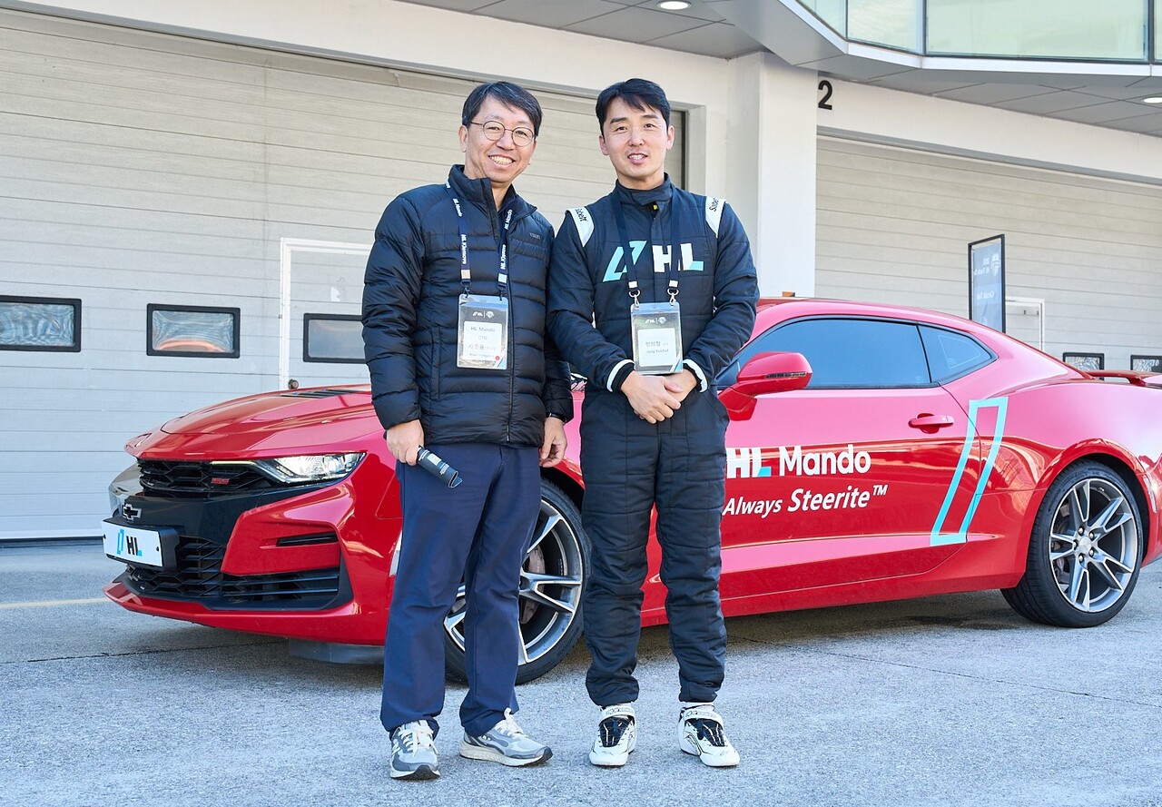 배홍용 HL만도 최고기술책임자(CTO)이자 부사장과 정의철 카레이서(오른쪽)가 스티어바이와이어(Steer by Wire) 탑재 차량 앞에서 기념 촬영을 하고 있다. 2025.11.4./사진=HL그룹