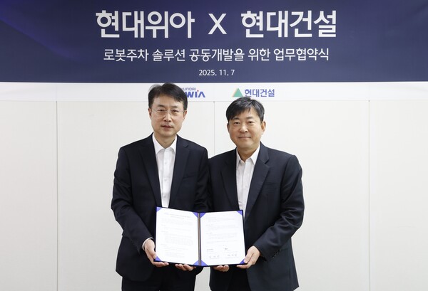 2025년 11월 7일 경기도 의왕시 현대위아 의왕연구소에서 열린 '로봇 친화형 주차솔루션 공동개발을 위한 업무협약식'에서 김재영 현대건설 기술연구원 원장(오른쪽)과 백익진 현대위아 모빌리티솔루션사업부 상무가 기념사진을 촬영하고 있다. /현대건설