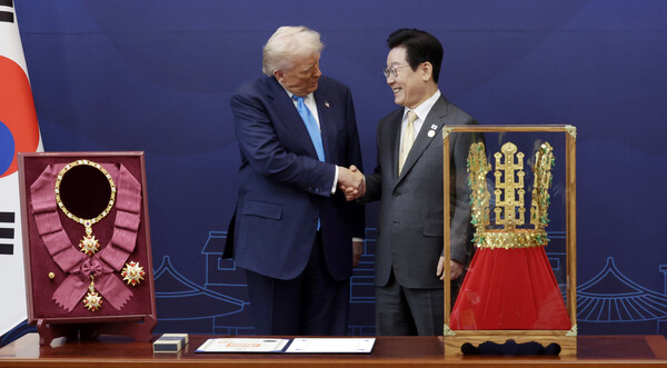 이재명 대통령이 29일 경북 경주박물관에서 도널드 트럼프 미국 대통령에게 '천마총 금관 모형'을 선물한 뒤 악수하고 있다. 왼쪽은 이 대통령이 트럼프 대통령에게 수여한 무궁화 대훈장. 2025.10.29 [대통령실통신사진기자단]