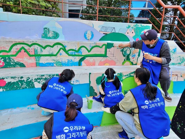 우리은행 임직원과 아이들이 함께 벽화 그리기 봉사활동에 참여하고 있다./2025.11.17 우리은행