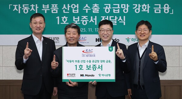 하나은행은 2025년 11월 17일 HL만도, 한국무역보험공사와 '자동차 부품산업 수출 공금망 강화를 위한 금융지원' 1호 지원 기업인 케이에이씨를 방문해 보증서를 전달했다. 강원도 원주시 케이에이씨 반계공장에서 열린 이번 행사에 참석한 진건창 하나은행 외환사업본부장(사진 왼쪽에서 세번째)이 김성일 HL만도 부사장(사진 왼쪽에서 첫번째), 하영봉 케이에이씨 대표이사(사진 왼쪽에서 두번째), 장진욱 한국무역보험공사 부사장과 기념촬영을 하고 있다./사진=하나은행