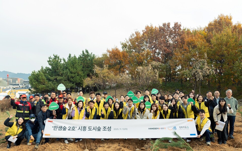 경기도 시흥 거북섬에서 진행된 ‘한샘숲 2호’ 조성 행사에 참가한 사람들이 기념 사진을 촬영하고 있다. 이번 행사에는 한샘 임직원 40여 명이 참여해 나무심기 봉사활동을 펼쳤다. 2025.11.19./사진=한샘