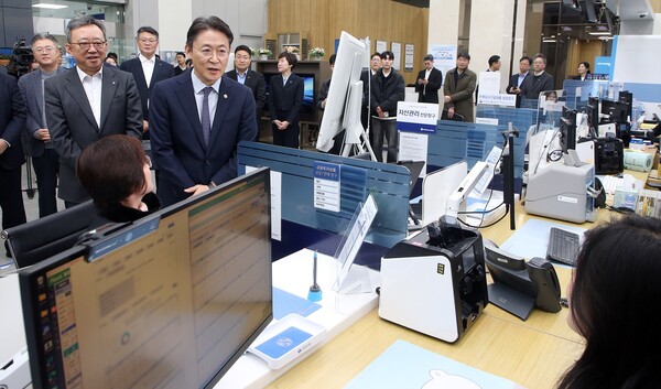 2025년 11월 19일 서울시 중구 신한은행 광교영업부에서 진행된 '오프라인 오픈뱅킹·마이데이터 서비스 시연행사'에서 정상혁 신한은행장(뒷편 왼쪽)과 권대영 금융위원회 부위원장(오른쪽)이 서비스에 대한 직원설명을 듣고 있다./사진=신한은행