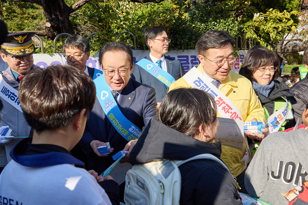 2025년 11월 18일 김인 새마을금고중앙회장(가운데 왼쪽)과 윤호중 행정안전부 장관 및 기타 관계자들이 부산 수영구에 위치한 광남초등학교에서 어린이 등·하굣길 안전 확보를 위해 안전물품과 리플릿 등을 나눠주고 있다./사진=새마을금고중앙회