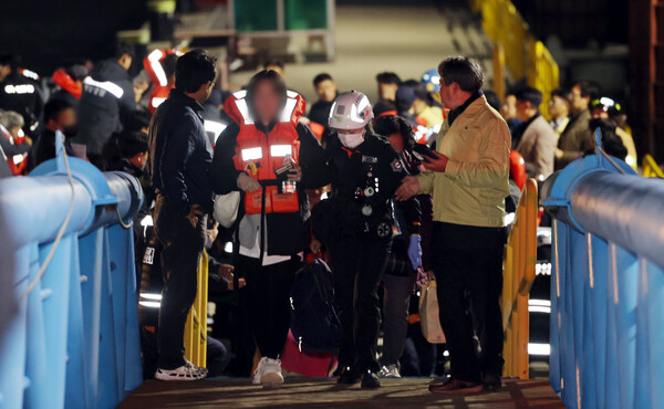 2025년 11월 19일 오후 전남 목포시 목포해양경찰서 전용 부두로 여객선 퀸제누비아2호 탑승객들이 구조돼 이동하고 있다./연합