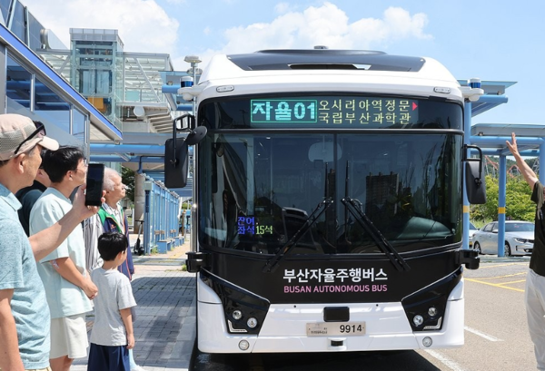 2025년 8월25일 부산시 기장군 오시리아역 버스 탑승장에서 부산자율주행버스(BigAi) 시승 체험행사에 참여한 시민들이 시행사 관계자에게 설명을 듣고 있다./연합